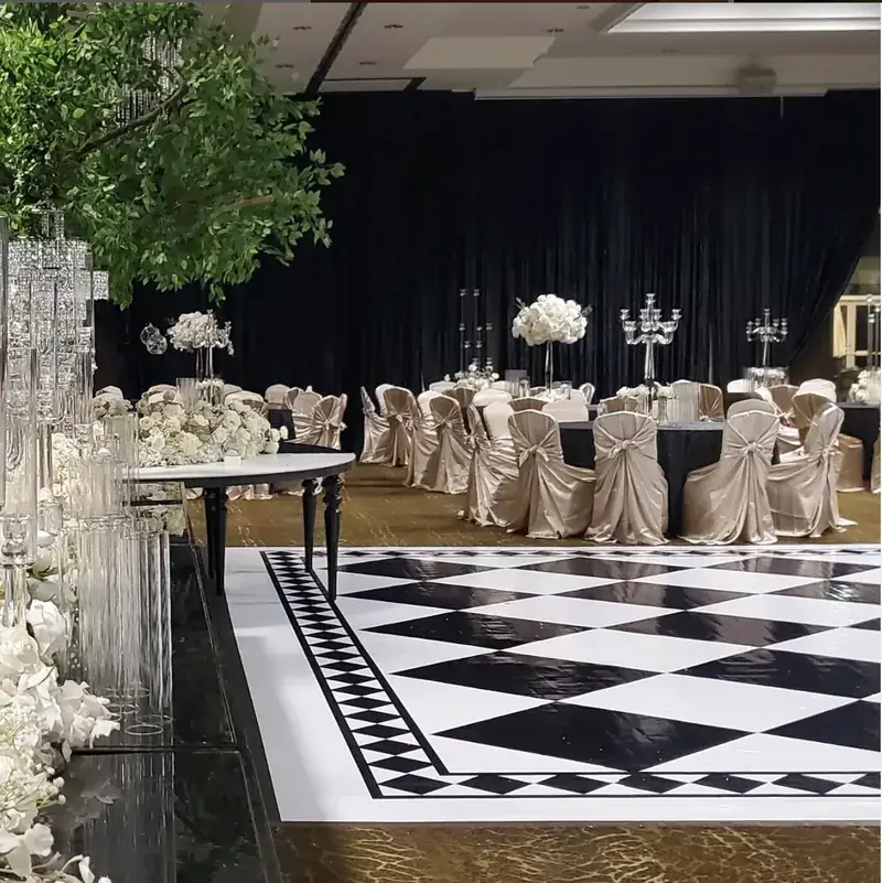Black draping, checkerboard dance floor and white florals