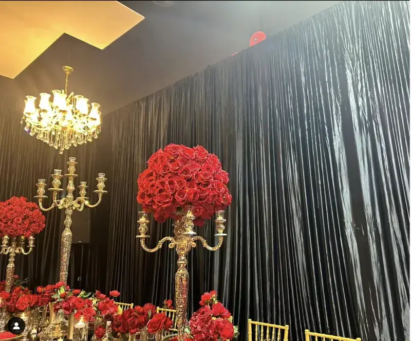 Black draping with red roses and gold candelabras