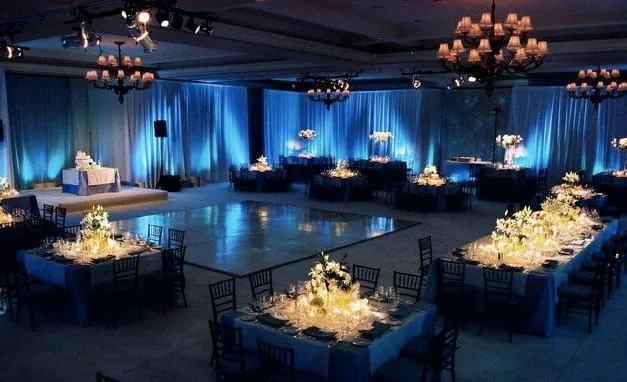 Blue-lit event hall with glowing centrepieces