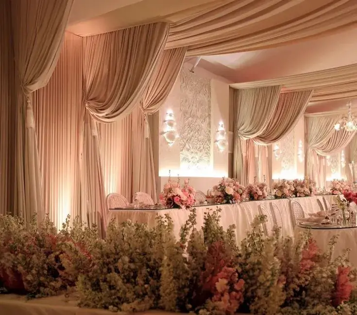 Blush draping with floral stage and head table