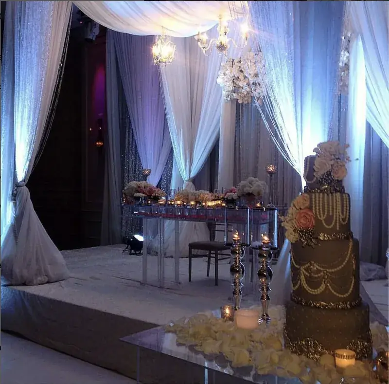 Ivory draped reception with florals and cake display