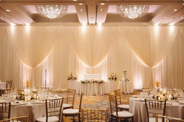 Ivory wall draping and head table in a banquet hall