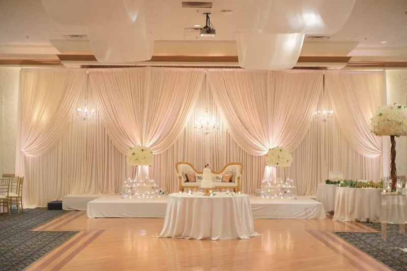 Ivory wall-to-wall draping with head table and uplighting