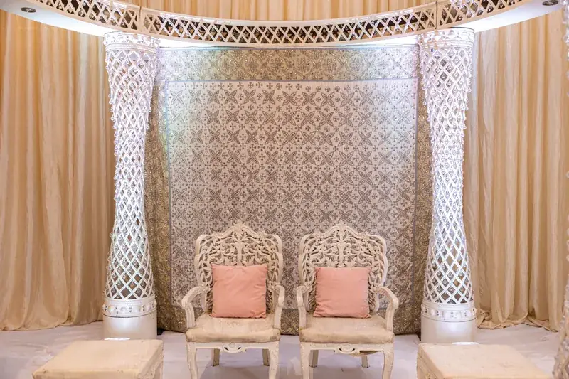 Palazzo Mandap seating with blush chairs and white jali panels