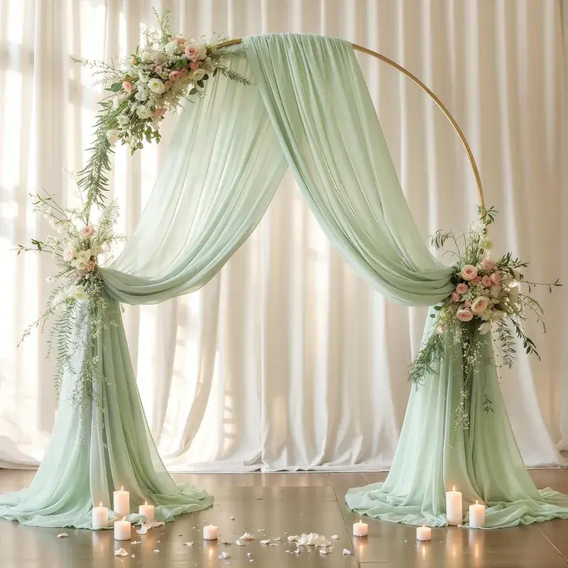 Sage green fabric arch with florals and candles