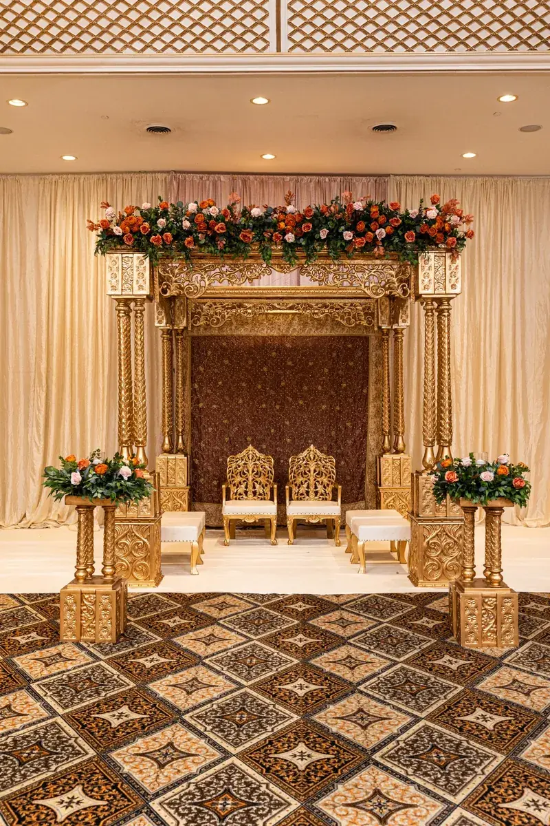 Shreya Mandap: carved gold mandap with floral garland
