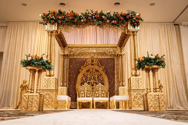 Shreya Mandap: gold carved stage with florals on patterned carpet